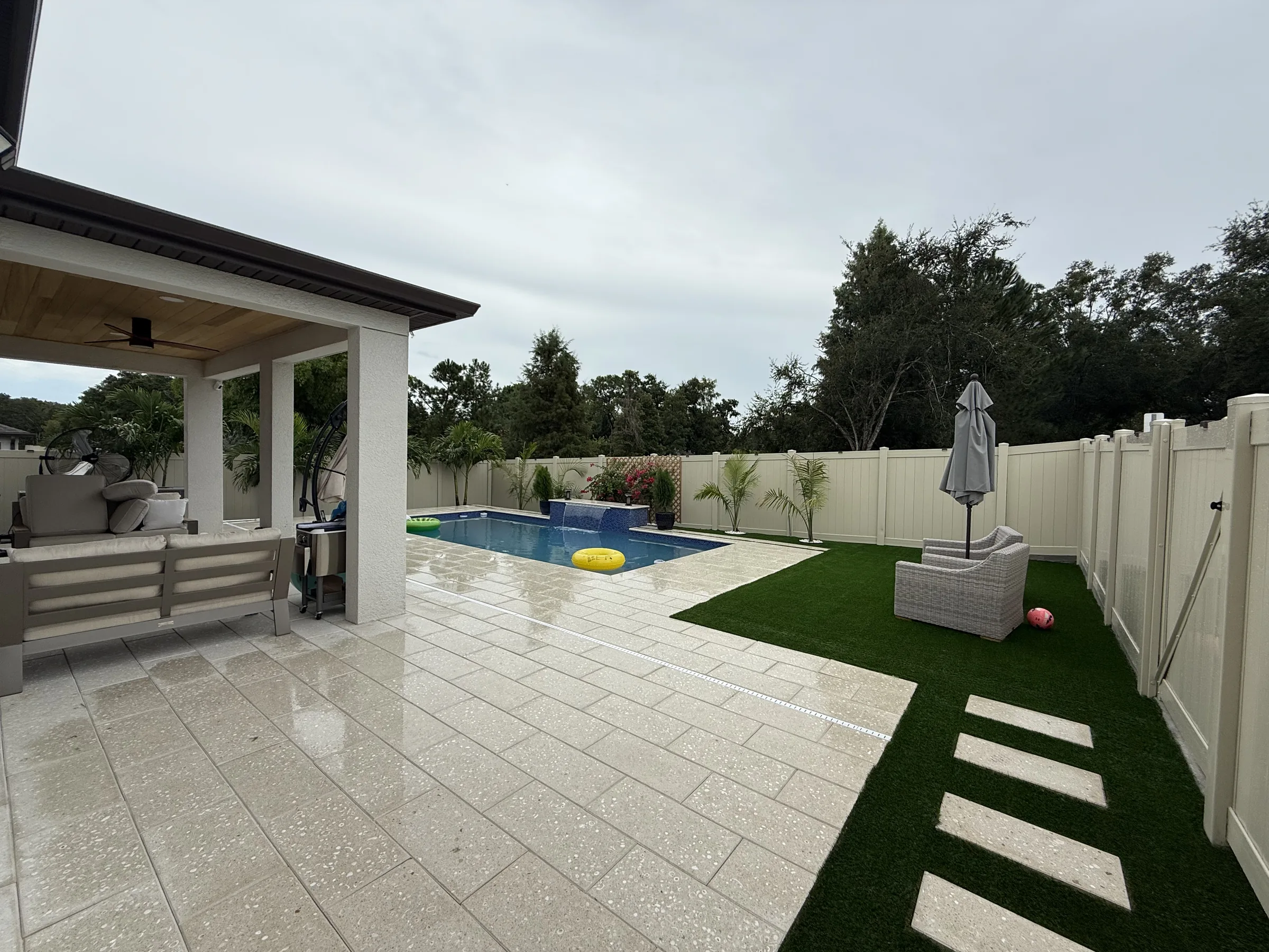 Finished custom rectangular Acqua Bella pool with paver deck and screen enclosure, Trinity FL